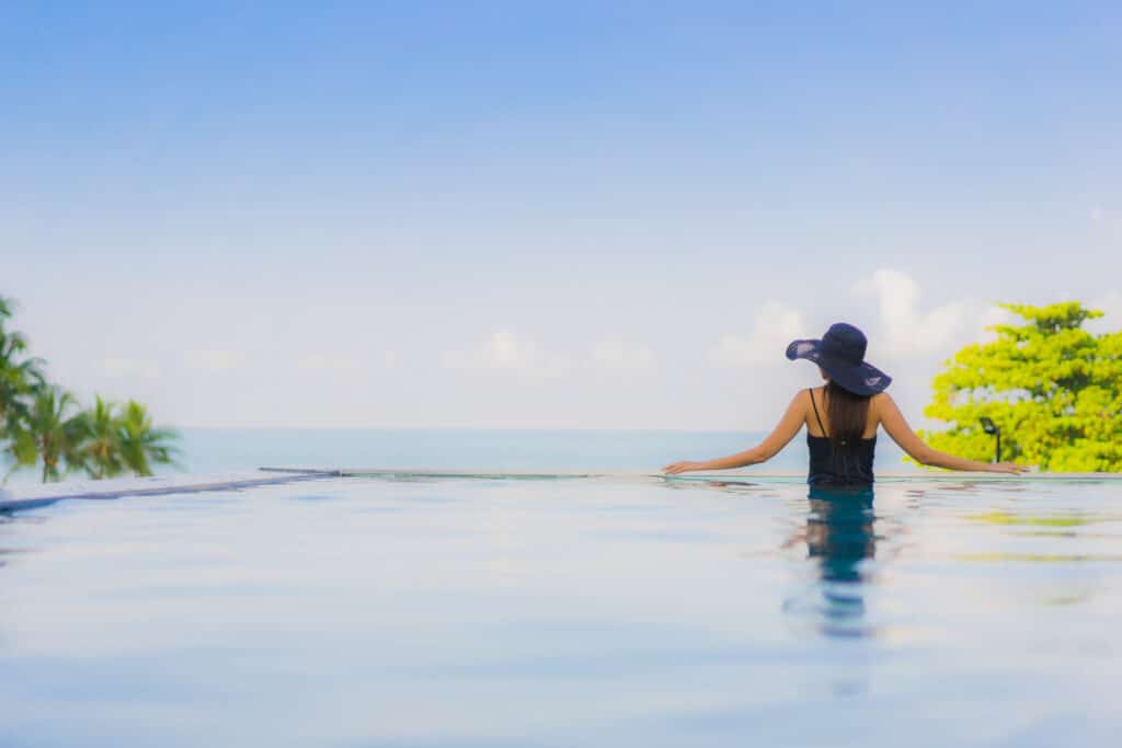 ผู้หญิงยืน พูลวิลล่าสัตหีบ อยู่ในสระน้ำโดยสวมหมวก