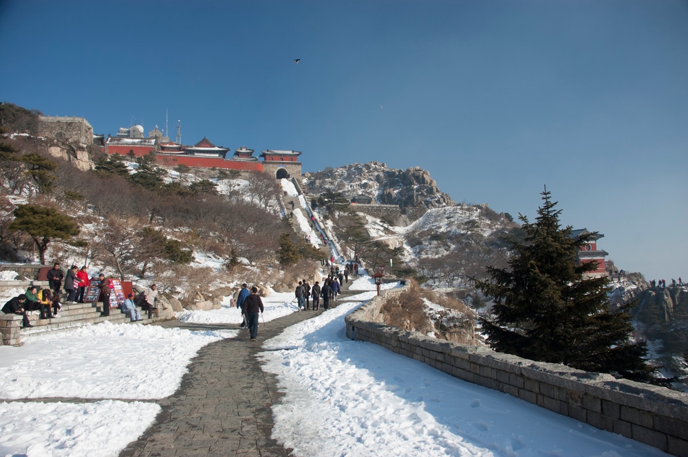 กลุ่มคนกำลัง สถานที่ท่องเที่ยวในจีน เดินขึ้นเขาที่ปกคลุมด้วยหิมะ