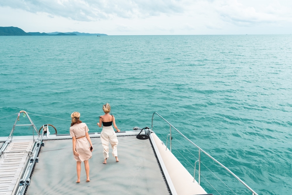 ผู้หญิงสองคนกำ เกาะล้าน ลังเดินอยู่บนดาดฟ้าเรือ