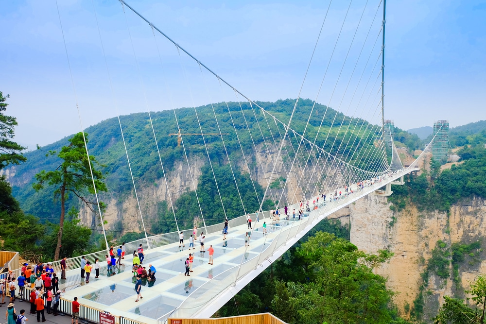 กลุ่มคนกำลังเดินข้ามสะพานแขวน สถานที่ท่องเที่ยวจีน