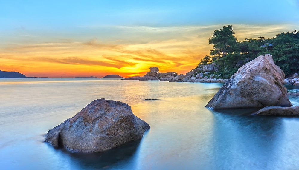 พระอาทิตย์ ที่เที่ยวเวียดนาม ตกที่สวยงามเหนือมหาสมุทรโดยมีโขดหินอยู่เบื้องหน้า