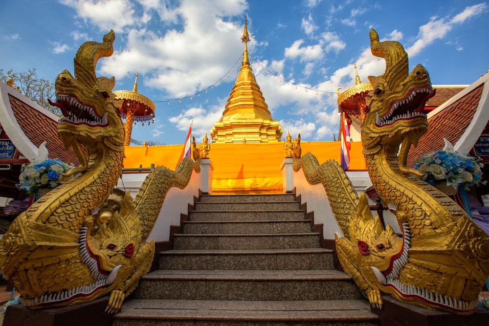 Veranda High Resort Chiangmai วัดพระธาตุดอยคําหลวงพ่อทันใจ รูปปั้นมังกรทองขนาดใหญ่นั่งอยู่บนบันไดชุดหนึ่ง