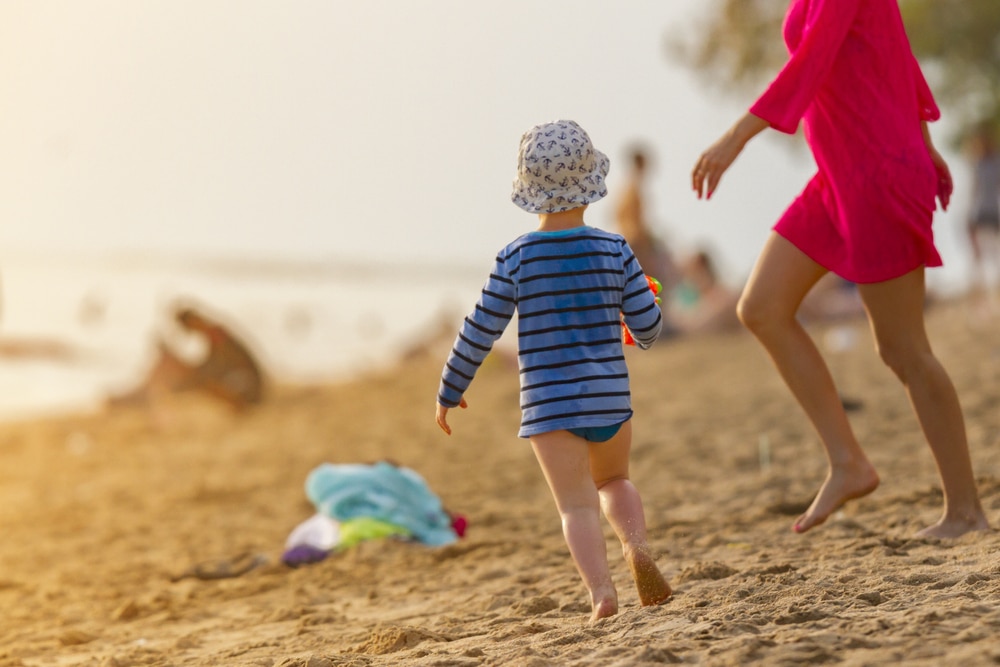 ผู้หญิงและเด็กกำลังเดินอยู่บนชายหาด หาดจอมเทียน