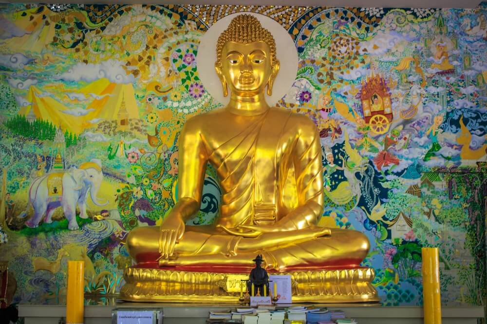 พระพุทธรูป ที่เที่ยวสะเมิง ทองคำนั่งอยู่หน้ากำแพงสี