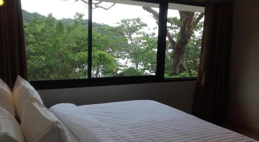 ห้องนอนที่มีหน้าต่างบานใหญ่มองเห็นต้นไม้ในแหล่งท่องเที่ยวจันทบุรี จันทบุรีที่เที่ยว