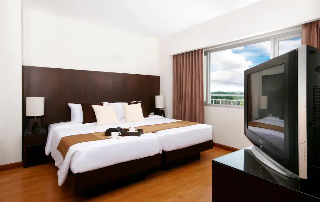 ห้องพักพร้อมเตียง 2 ที่พักกบินทร์บุรี เตียงและโทรทัศน์จอแบนที่โรงแรมหรือรีสอร์ทในกบินทร์-บุรี
