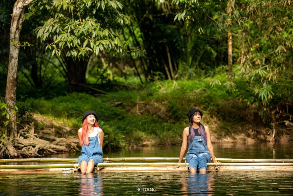 ผู้หญิงสองคนนั่งอยู่บนขอนไม้ในแม่น้ำที่เขาหลักที่เที่ยว เขาหลักที่เที่ยว