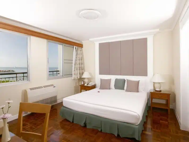 ห้องนอนที่มีเตียงขนาดใหญ่และหน้าต่างในห้องพักของโรงแรม ที่พักแกลง