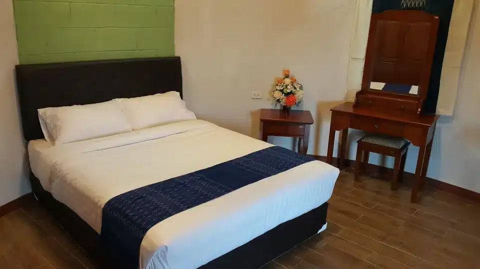 ห้องนอนพร้อมเตียง ตู้เสื้อผ้า และกระจก ในราชบุรีเพื่อการท่องเที่ยว เที่ยวเขมราฐ