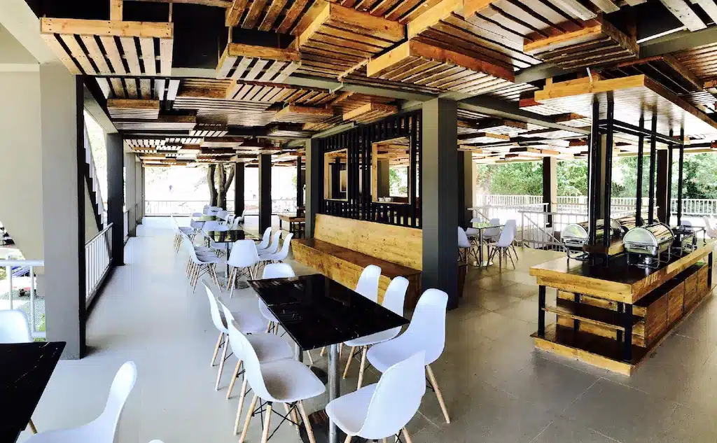 ร้านอาหารที่มีโต๊ะและเก้าอี้สีขาวอยู่ในสถานที่ท่องเที่ยวในจังหวัดราชบุรี