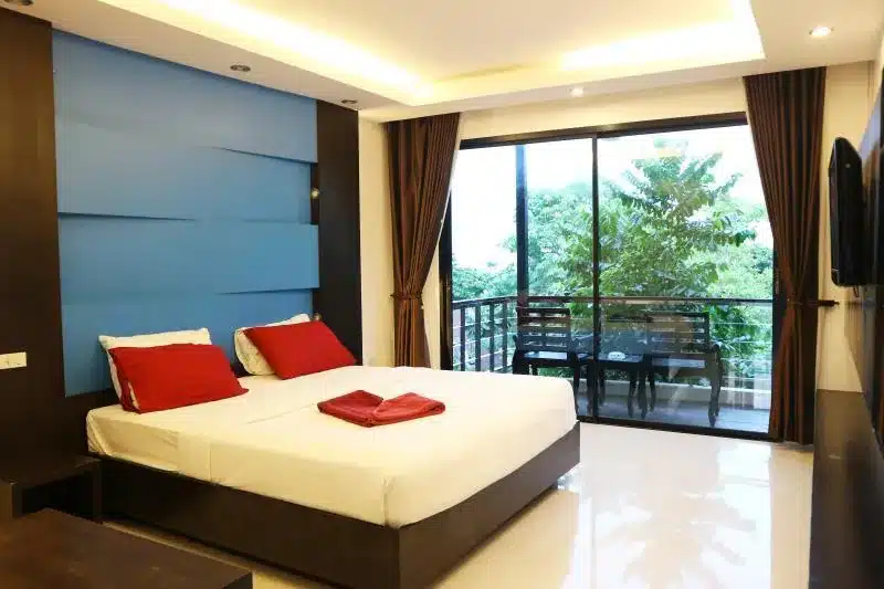 เตียงที่ทำอย่างประณีตและทีวีจอแบนในห้องนอนใน เกาะเสม็ดที่พัก สถานที่ท่องเที่ยวยอดนิยมของประเทศไทย