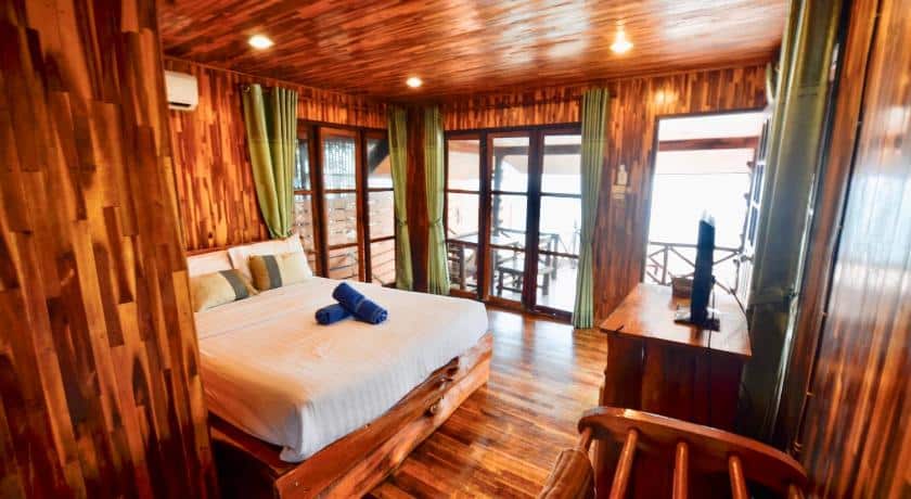 เตียงนอนผนังไม้ในห้องของบ้านพักริมน้ำเกาะล้าน