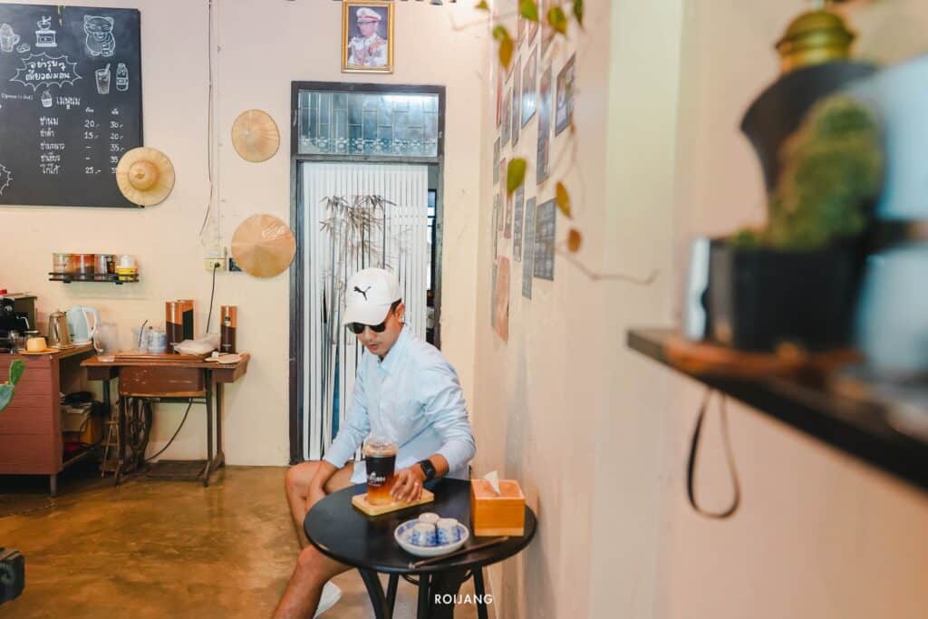 ผู้ชายกำลังกินอยู่ที่โต๊ะในร้านกาแฟในพังงา ร้านกาแฟพังงา