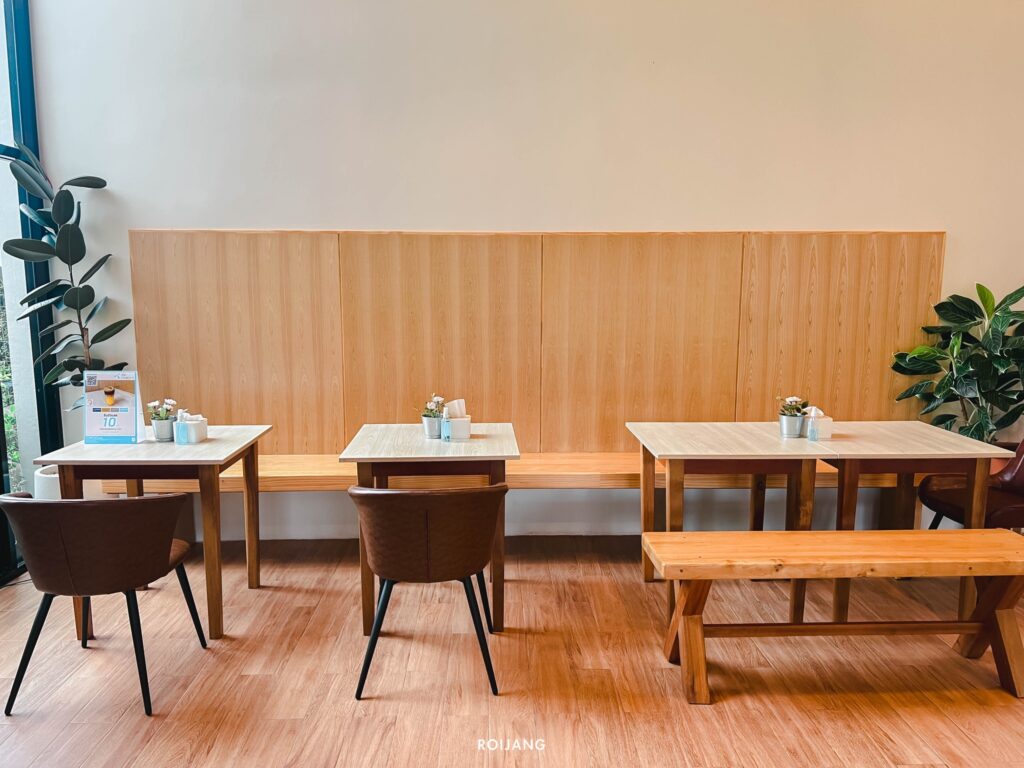 คาเฟ่พังงาที่มีโต๊ะและเก้าอี้ไม้และต้นไม้ ร้านกาแฟพังงา