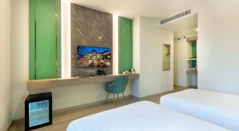 ห้องพักในโรงแรมที่มีสองเตียงและทีวีจอแบนในสถานที่ท่องเที่ยวบ้านโป่ง เที่ยวบ้านโป่ง