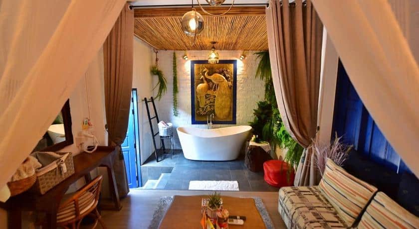 ห้องน้ำพร้อมอ่างอาบน้ำและโซฟาในรีสอร์ทริมน้ำในราชบุรี เหมาะสำหรับนักเดินทางที่สำรวจจังหวัด