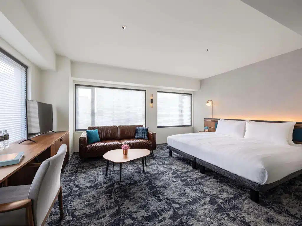 ห้องพักโรงแรมในโอซาก้าพร้อมเตียงและโต๊ะ โอซาก้าที่เที่ยว