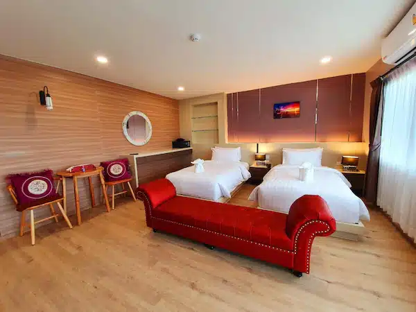 ห้องพักโรงแรม 2 เตียงและโซฟาสีแดงในราชบุรีที่เที่ยว ที่พักติดทะเลจันทบุรี