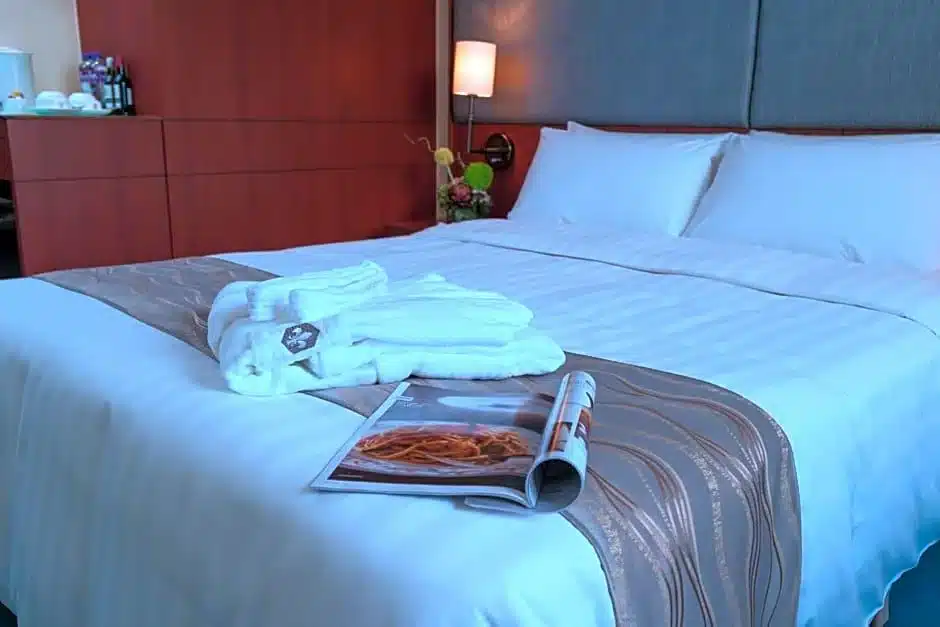 ห้องพักในโรงแรมที่มีเตียงและนิตยสารบนเตียงใน ที่เที่ยวฮ่องกง