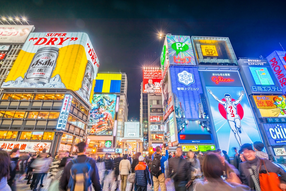 ถนนที่มีคนพลุกพล่านในโตเกียวในยามค่ำคืนพร้อมป้ายโฆษณามากมาย เที่ยวได้ ที่เที่ยวโอซาก้า
