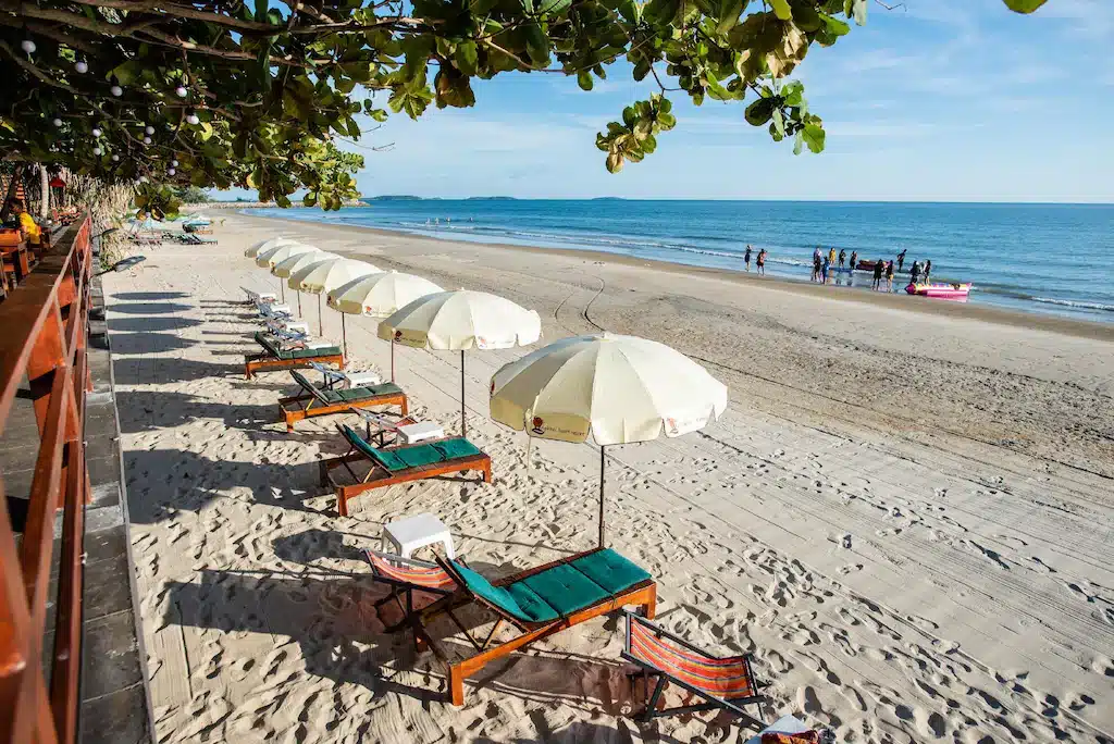 เที่ยวช้างกลาง ชายหาดที่มีเก้าอี้นั่งเล่นและร่มเรียงรายอยู่บนพื้นทราย ที่พักแหลมแม่พิมพ์