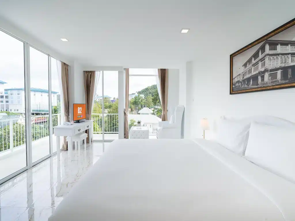 ห้องนอนสีขาวพร้อมระเบียงชมวิวเมือง ที่พักภูเก็ตราคาถูก