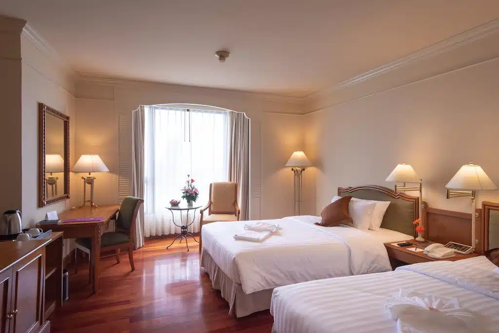 ห้องพักในโรงแรมที่มีสองเตียงและโต๊ะทำงานตั้งอยู่ในกรุงเทพฯ ที่เที่ยวกรุงเทพมหานคร