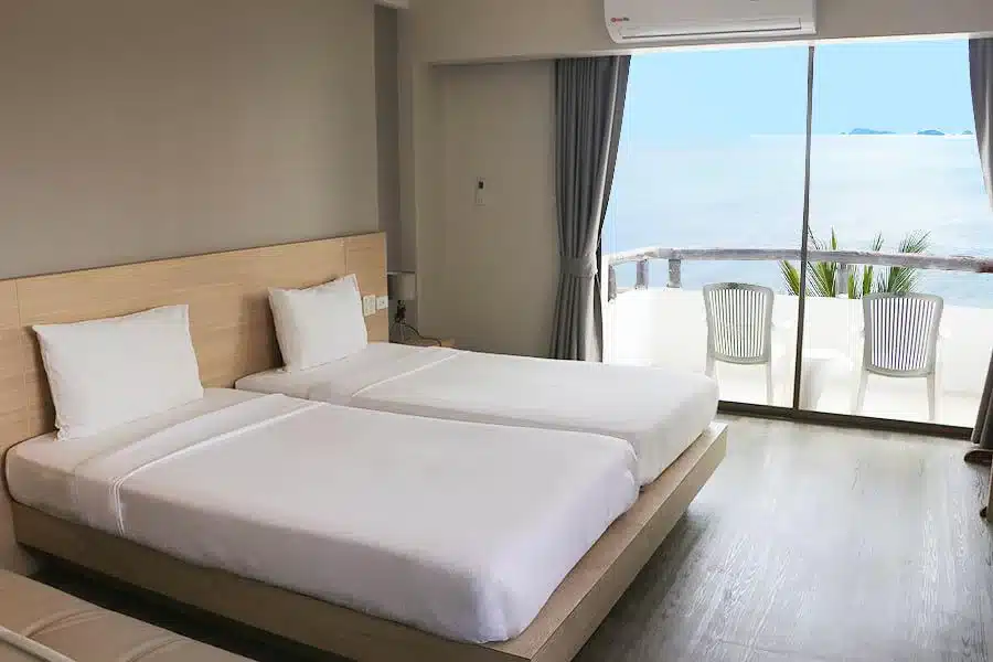 ห้องพักในโรงแรมที่มีเตียง 2 เตียงและระเบียงที่มองเห็นทะเล ที่พักระยองติดทะเล