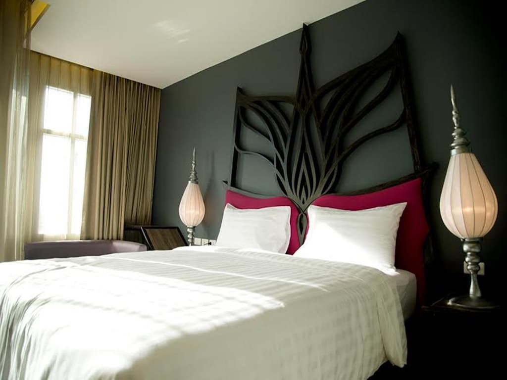 เตียงในห้องพักโรงแรมที่มีหัวเตียงขนาดใหญ่ที่มีวัฒนธรรมและสถาปัตยกรรมของวัดพัญเชิง เจ้าแม่สร้อยดอกหมาก