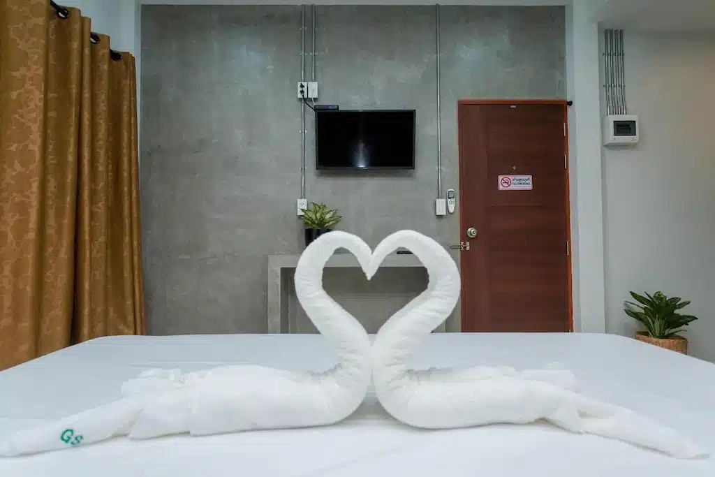 หงส์ 2 ตัวทำผ้าเช็ดตัวบนเตียงในห้องที่พักริมชายหาดในระยอง โรงแรมท่าศาลา