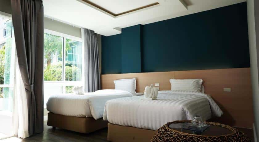 เกมส์ภูเก็ตราคาถูกกับสองเตียงในห้องที่มีผนังสีฟ้า โรงแรมระยอง