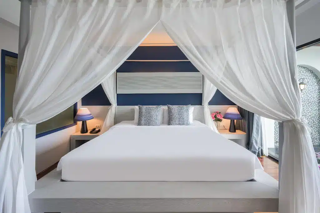 ที่พักภูเก็ต ราคาถูก ห้องนอนพร้อมเตียงกระโจมสีขาวและผ้าม่านสีน้ำเงิน