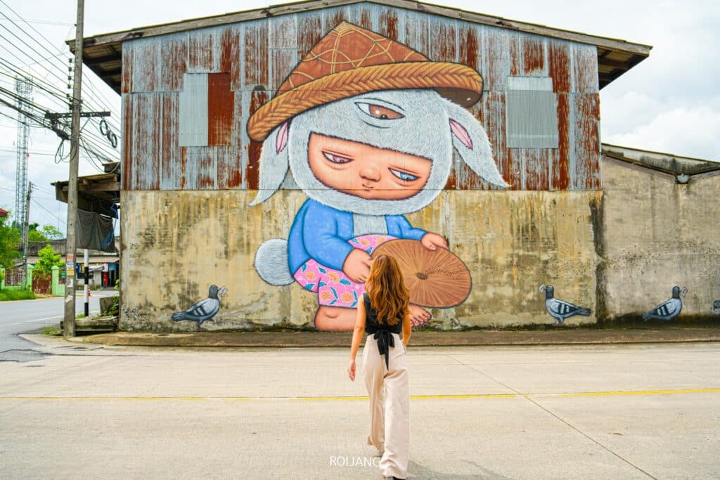 สาวท่องที่เที่ยวพังงากับภาพจิตรกรรมฝาผนังอาคาร ที่เที่ยวพังงา