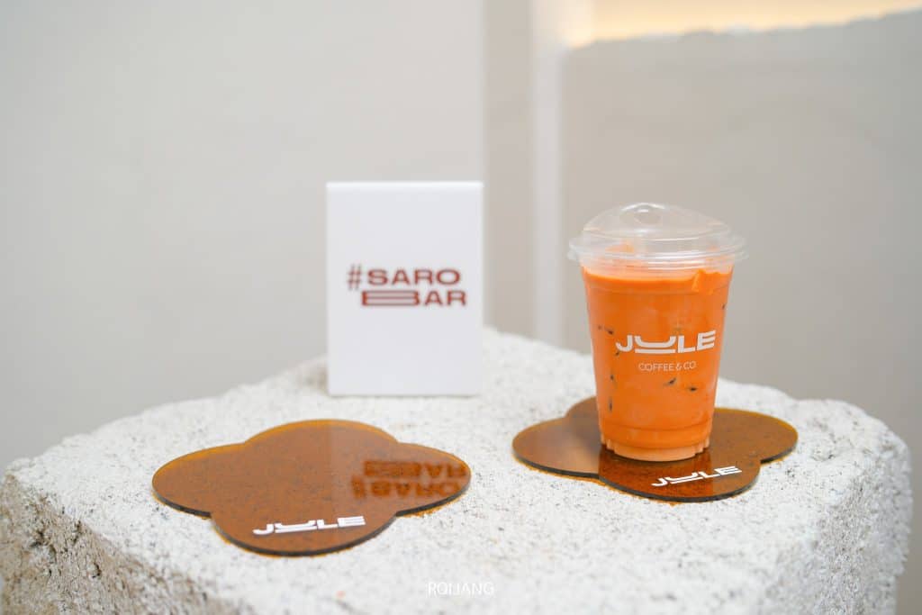 น้ำส้มหนึ่งแก้วและกาแฟหนึ่งถ้วยบนโต๊ะใน ร้านกาแฟภูเก็ต