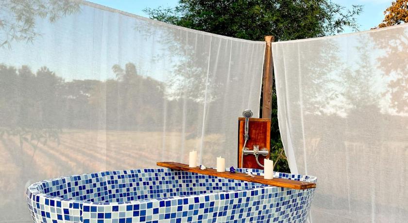 อ่างอาบน้ำปูกระเบื้องสีฟ้าขาวบนชานไม้ที่ชุมแพ ที่พักเชียงของ