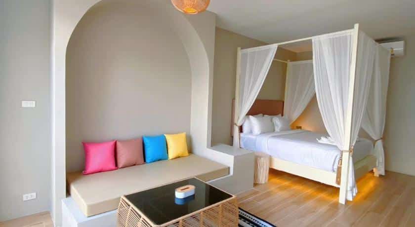 ห้องที่มีเตียงสีขาวและหมอนสีสันสดใสที่ที่พักด่านซ้าย ที่พักช้างกลาง