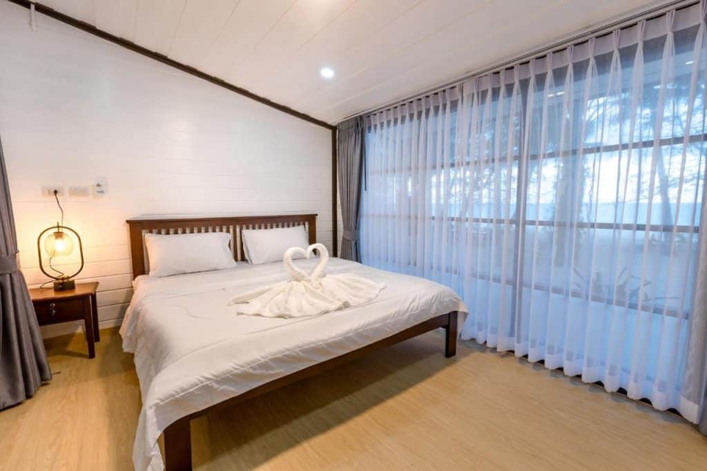 ห้องนอนริมชายหาดพร้อมเตียงและผ้าเช็ดตัวบนเตียง ที่พักท่าศาลา