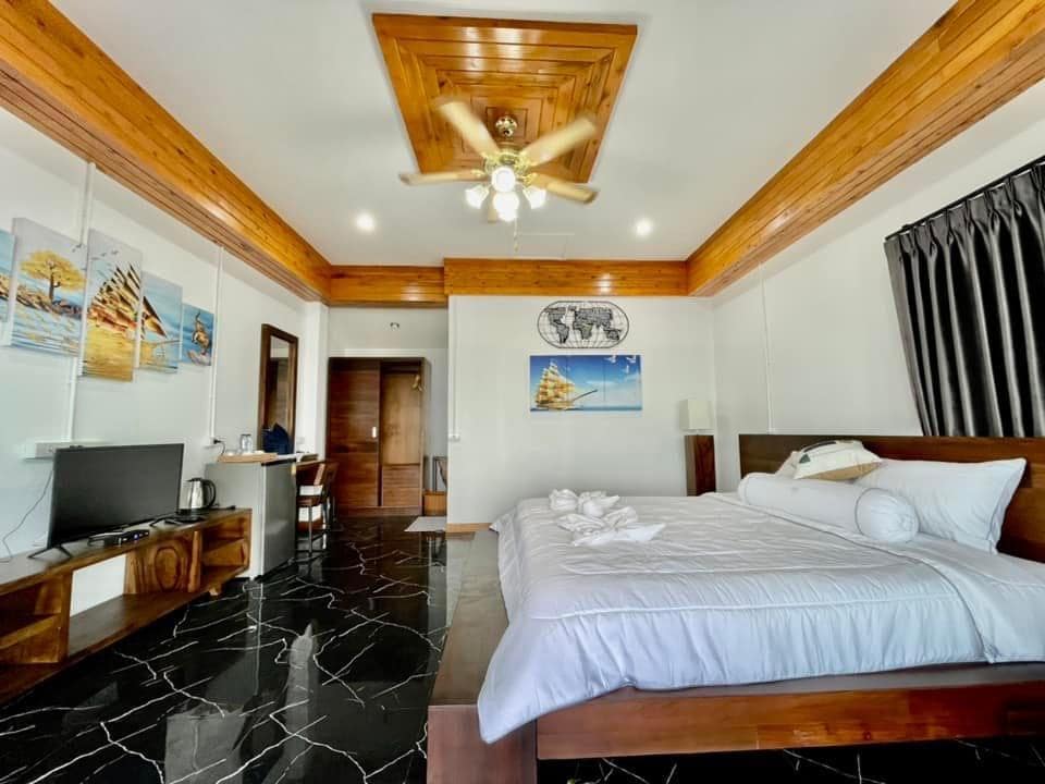 ห้องนอนริมชายหาดพร้อมเตียง ทีวี และพัดลมเพดาน ที่พักท่าศาลา