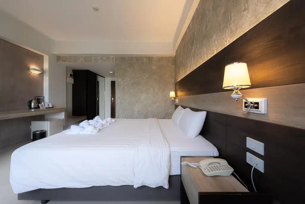 ห้องพักในโรงแรมที่มีเตียงขนาดใหญ่และทีวีจอแบน สถานที่ท่องเที่ยวนครปฐม