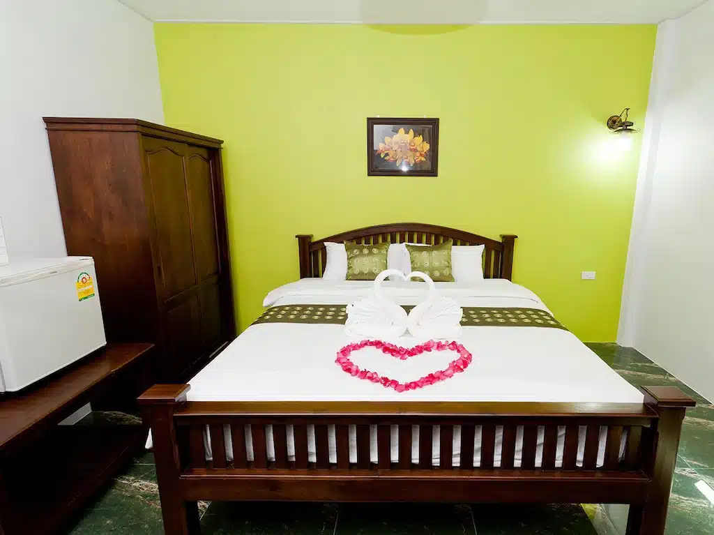 ห้องที่มีผนังสีเขียวและเตียงรูปหัวใจ โรงแรมตะกั่วป่า