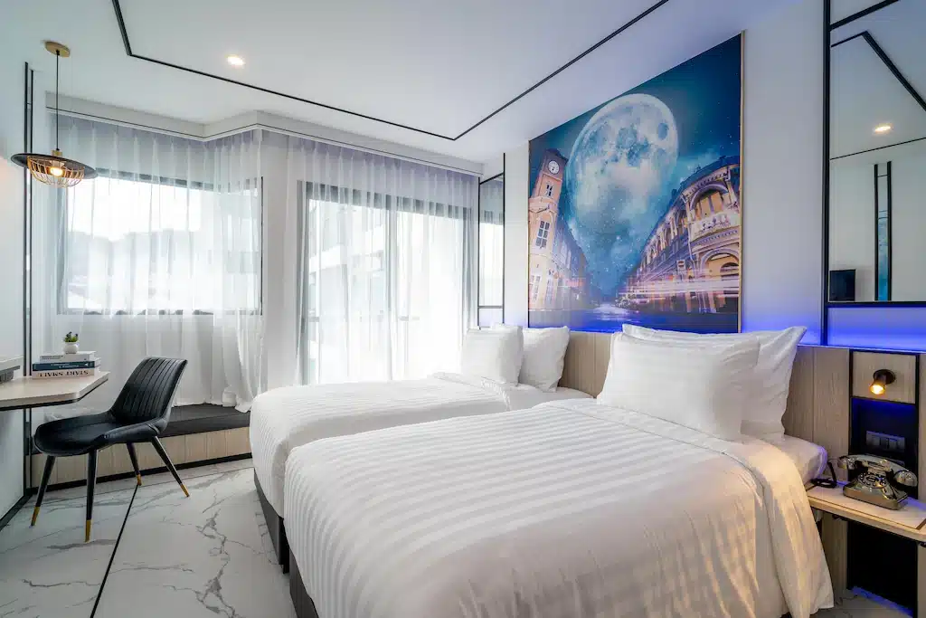 ห้องพักในโรงแรมที่มีสองเตียงและภาพวาดบนผนัง ที่พักภูเก็ต