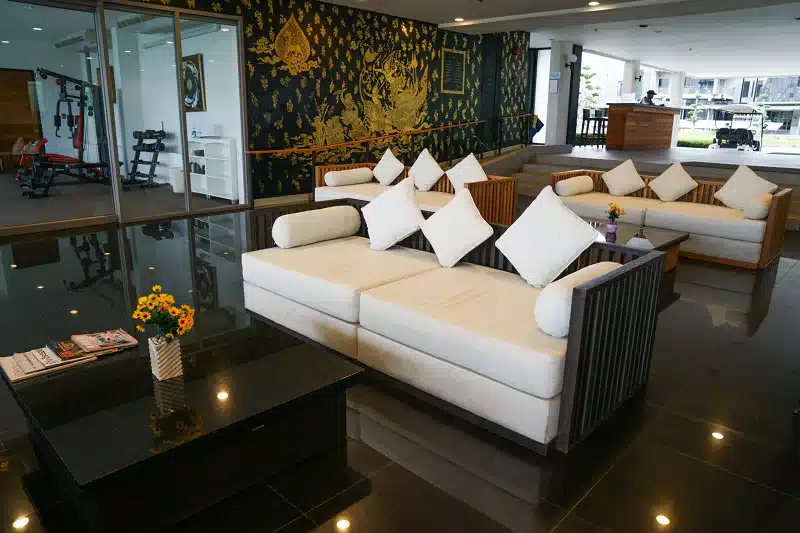 ห้องนั่งเล่นในโรงแรมภูเก็ตพร้อมโซฟาสีขาวและโต๊ะกาแฟ ที่พักระยอง ที่พักติดทะเลระยอง