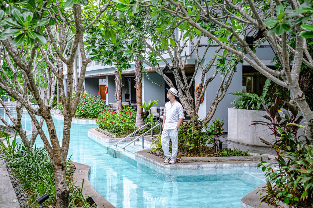 ชายคนหนึ่งยืนอยู่ข้างสระน้ำของ Health Land Resort & Spa Pattaya