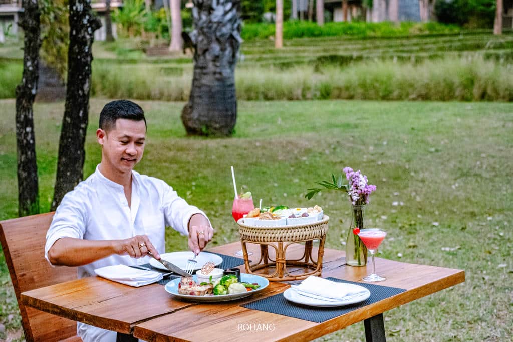 ผู้ชายกำลังรับประทานอาหารที่โต๊ะที่ Veranda High Resort Chiangmai .