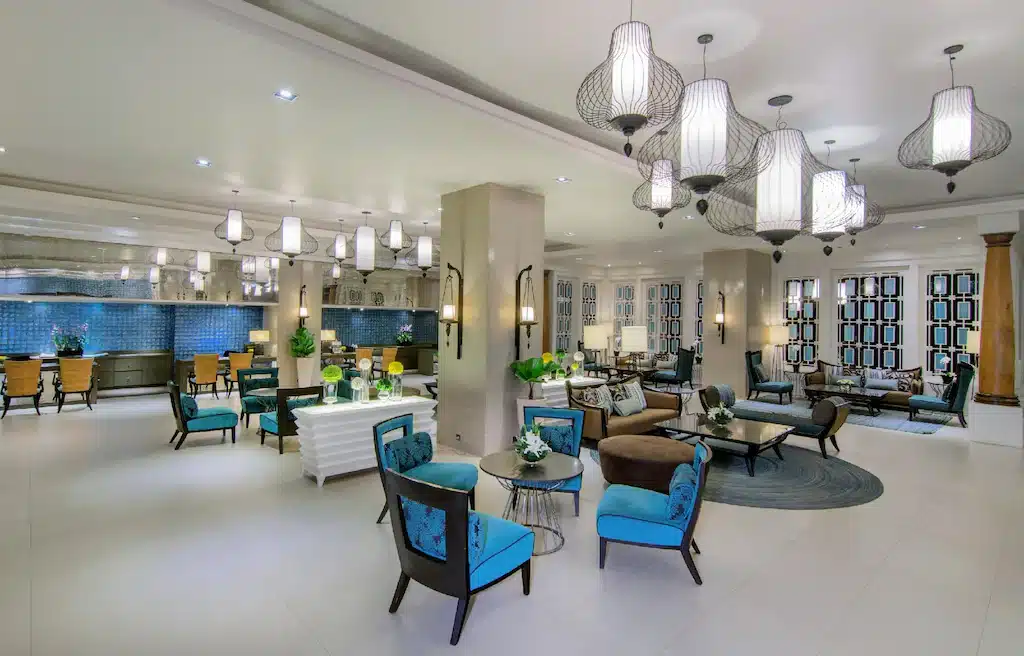 ล็อบบี้โรงแรมริมชายหาดพร้อมเก้าอี้สีน้ำเงินและโคมระย้า รีสอร์ทพัทยาใต้