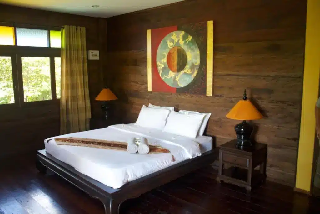 ห้องนอนริมชายหาดที่มีผนังไม้และเตียงนอนในพัทยาใต้ ที่พักดอยสะเก็ด