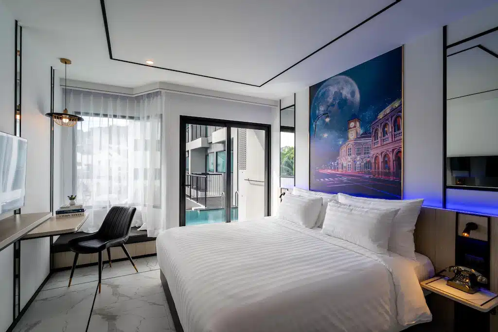 ห้องพักในโรงแรมพร้อมเตียงและภาพวาดบนฝาผนัง ที่พักภูเก็ต