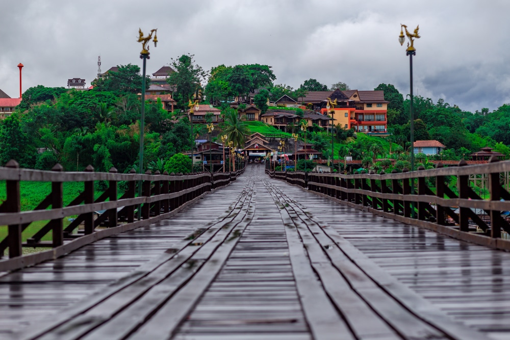 สะพานไม้ที่นำไปสู่หมู่บ้านในนครนายก สถานที่ท่องเที่ยวยอดนิยมของภาคกลาง ที่เที่ยวภาคกลาง