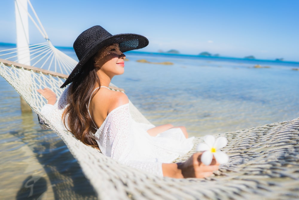 ผู้หญิงสวมหมวกขาวกำลังพักผ่อนที่ดอยเลาที่พัก ที่พักระยองติดทะเล