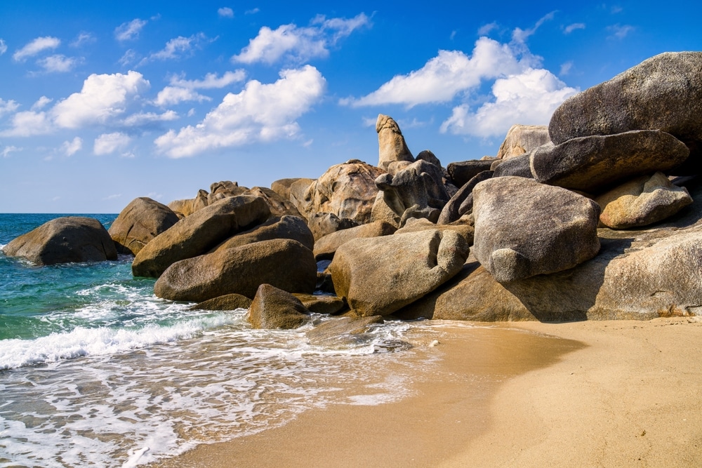 ชายหาดที่มีโขดหินขนาดใหญ่และท้องฟ้าสีคราม สถานที่ท่องเที่ยวสุราษฎร์ธานี